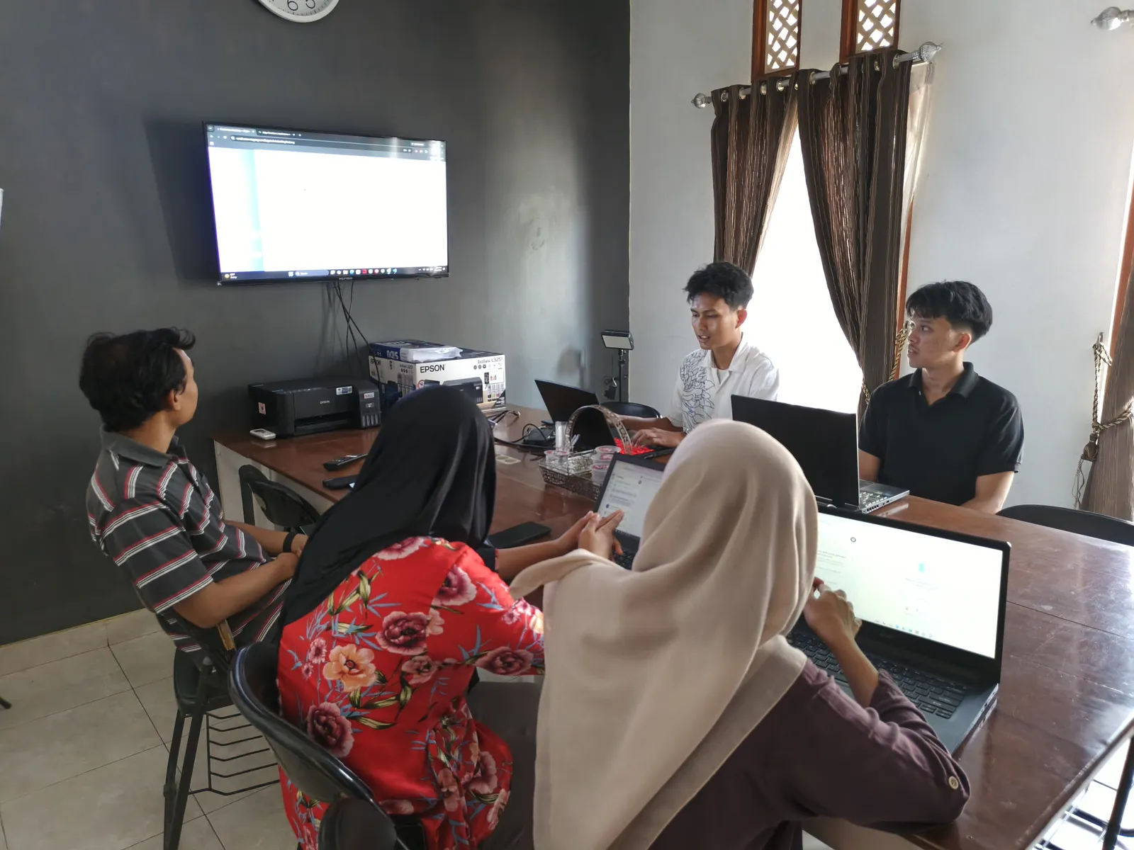 Peserta mempresentasikan progres pekerjaan di layar kepada mentor